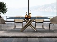 Table Ivy with sahara noir matte ceramic top and central base with interlocking champagne-painted metal legs matching the frame of the chairs