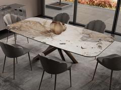 Table Ivy with a glossy patagonia ceramic top and bronze-painted metal base placed inside an elegant dining room