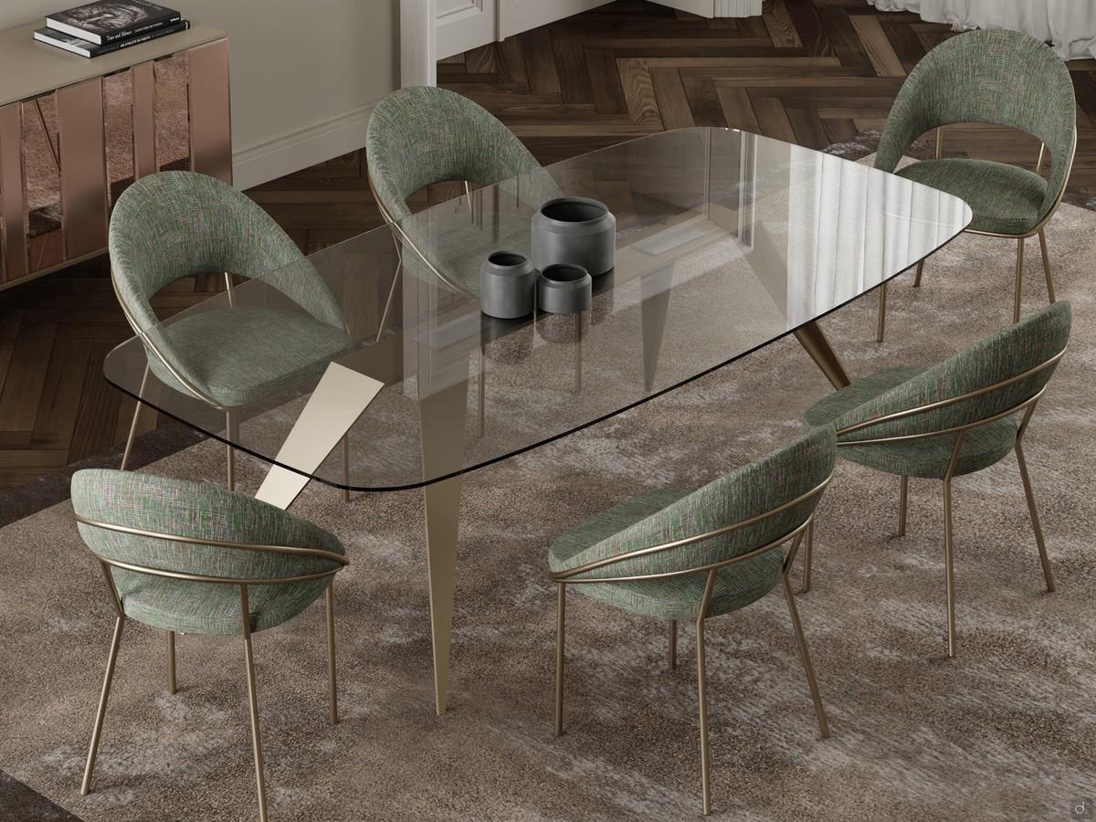 Glass table with pointed legs Pegaso paired with Kiki chairs, which pick up the champagne shade for the metal frame. The clear glass top enhances and enhances the characteristic base