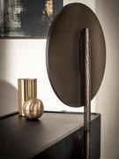 Detail of round swivel mirror with patinated bronze finish iron frame and stand