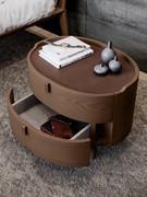 Detail of oval wooden bedside table Aries, with double drawer front. Wood veneer top to match the frame or (as pictured) covered in leather