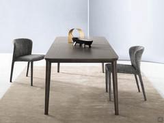 Extending table available in wood and ceramic, with a space to store the extensions under the table top