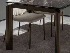 Perimeter legs with an elliptical shape, slightly protruding compared to the table top