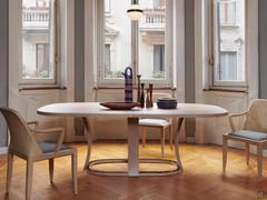 Extendable table Grace in the oval version, offered here in the light shade brushed ash stained beige: the ruthenium metal sheet protecting the base ring is very noticeable