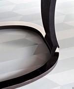 Detail of the circular metal base that connects the wooden legs of the Grace table to the ground