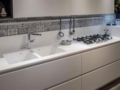 Detail of the top in solid surface with integrated sink and hob in white glass