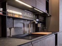 The linear wall kitchen opposite the island includes a sink with two bowls