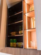 Wall-mounted pantry cabinet and open shelving compartments, embellished by LED lighting strips