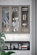 Wall cabinets with a latticed display case are used to create a bookcase that coordinates with the look of the kitchen