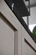 Detail of the framed door with solid wood profile from which the invisible handle is carved