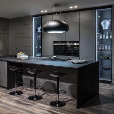 Modern kitchen with custom-made large central island and tall units with appliances and display cabinets