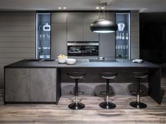 View of the front kitchen, with island equipped with snack counter and worktop complete with designer hood