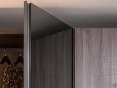 Detail of the mirror door with full-height curved groove in lead matte lacquered metal