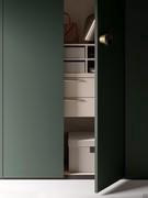 Suspended two-drawer chest of drawers and shirt raster embellished with storage boxes. The skin-effect veneer of the interior softens the forest green lacquer of the fronts