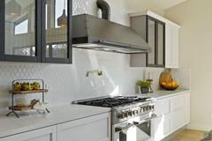 Detail of cooking block with industrial-style countertop and exposed hood