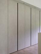 Linear wardrobe with hinged doors in Lotus Nature textured melamine and Brown lacquered metal nailing.