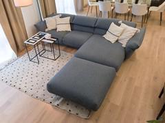 Sofa with chaise longue in blue fabric, with decorative cushions, side tables, rug