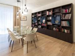 Dining area with table, chairs, large bookcase, hanging chandelier