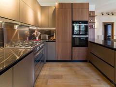 Kitchen with built-in refrigerator, oven and microwave columns in Canaletto Walnut wood veneer