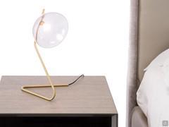 Bedside lamp Sunset with bent frame made of metal painted satin brass