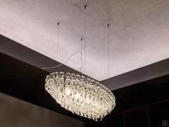 Detail of the oval metal structure from which the transparent crystal hooks of the Giogali lamp are hung