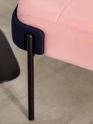 Detail of the matt black metal-tube legs that supports the upholstered sitting