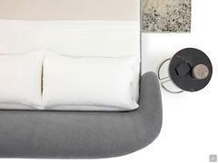 The large, soft upholstered headboard gently converges on the side bands