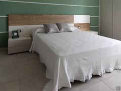 Double bed with natural wood paneling and white lacquer finish