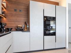 Kitchen columns for fridge and oven, with storage compartments.