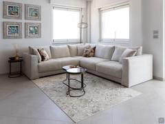 Clive corner sofa in white Diamond fabric, with side tables on the front and side of the sofa.