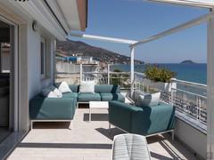 Large terrace with sofa, armchair and outdoor tables.