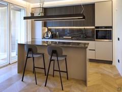 Kitchen island with cooking area and snack nook with high stools.