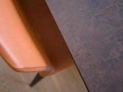 Detail of matte ceramic glass table top Ossido Bruno and leather chair