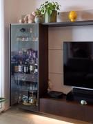 Tall display cabinet with glass door, internally organized with 3 shelves and a small drawer