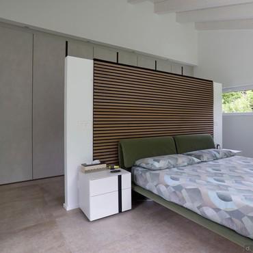 Room design with centre bed, partition wall and linear wardrobe