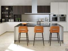 Detail of the island with steel top, designer hood and high upholstered stools