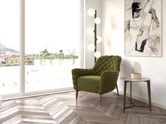 Relaxation corner of a spacious double bedroom. Furnished with designer armchair with capitonné upholstery, floor lamp, coffee table with opaque stone top.