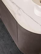 Detail of thin doors and curved structure covered in bronze-embossed metal: golden calacatta ceramic top