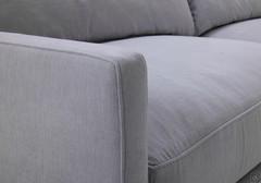 Detail of the thin armrest of the Maxime sofa covered in fabric, with matching cord on all seams.