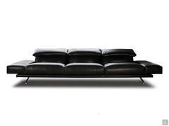 Heritage designer sofa upholstered in black leather with low, padded horizontal armrests