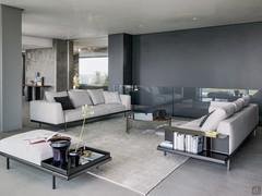 Double linear sofa Phil by Bonaldo and, in the foreground, the matching pouf with leather tray