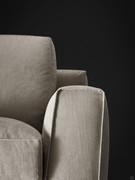 Detail of the upholstered armrest, lower than the backrest and meticulously finished with webbing