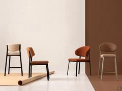 The Omnia collection includes both chairs and stools, not only in polypropylene but also (as seen in the photo) upholstered in fabric with various backrest shapes