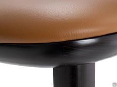 Detail of the leather seat fixed on the wenge-stained wooden frame