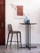 Hiru upholstered stool with solid wood legs coordinated with the Graphic bistro table top