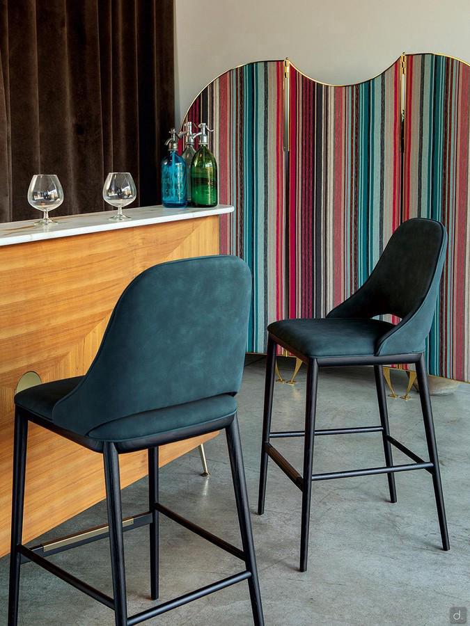 The Malva upholstered stool with curved backrest provides comfortable and elegant support