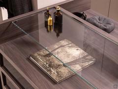 Practical double countertop created by the wooden dresser and glass top