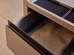 Drawer opening via matt lacquered metal groove also contrasting with the structure