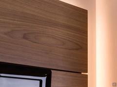 Wall panels veneered in Canaletto walnut, embellishing Replay 04 with the warmth of wood