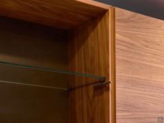 Detail of the interior veneered to match the exterior: note the clear glass shelf and the plunger of the push-pull opening system